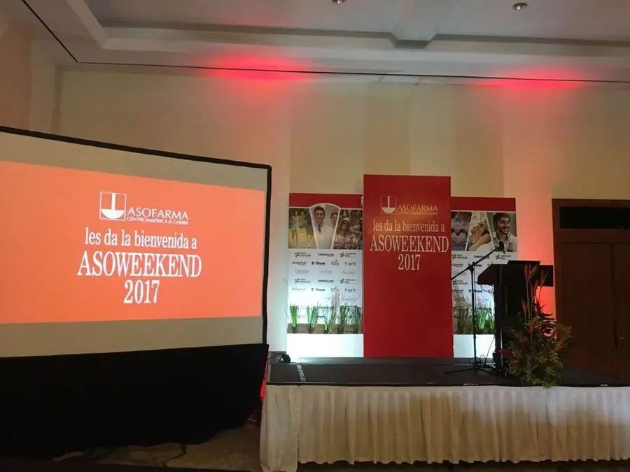 Escenario de Asoweekend 2017 de Asofarma, con pantalla de bienvenida, tarima con faldón y backdrop rojo