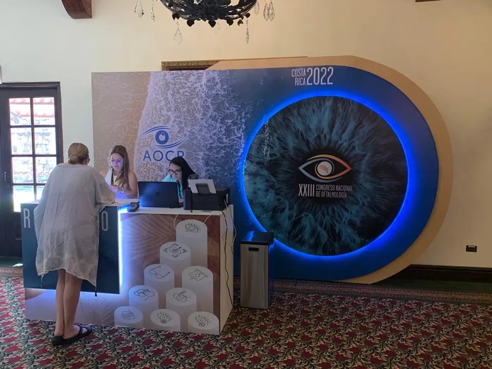 Área de registro del XXIII Congreso Nacional de Oftalmología Costa Rica 2022, con pieza circular retroiluminada en forma de ojo y mostrador