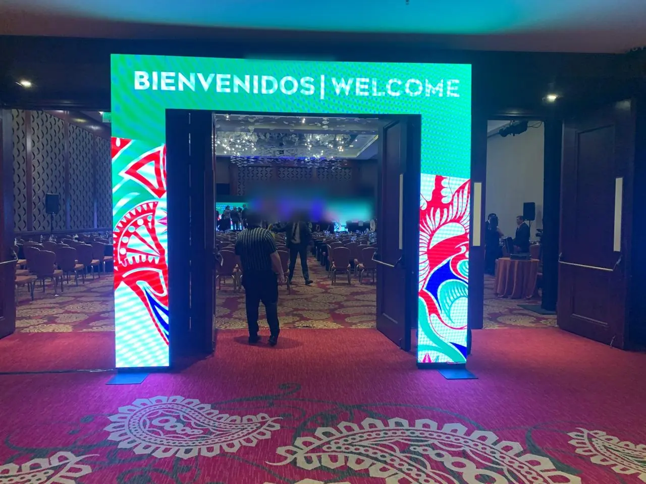 Portal de acceso con pantallas LED y la leyenda Bienvenidos | Welcome a la entrada de un salón de eventos
