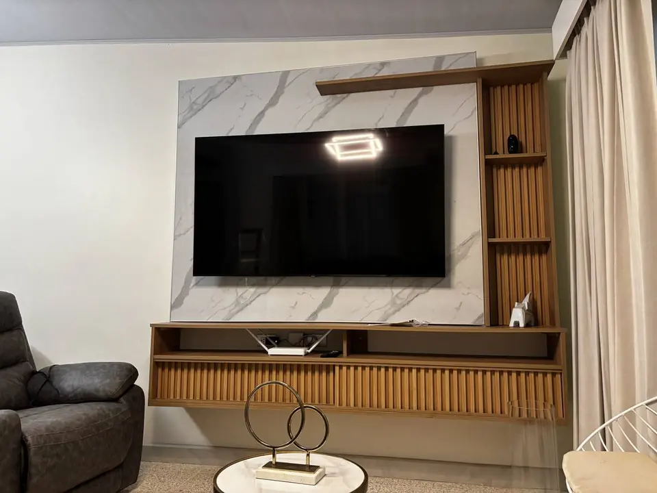 Mueble de sala a medida con paño de listones de madera y repisa suspendida